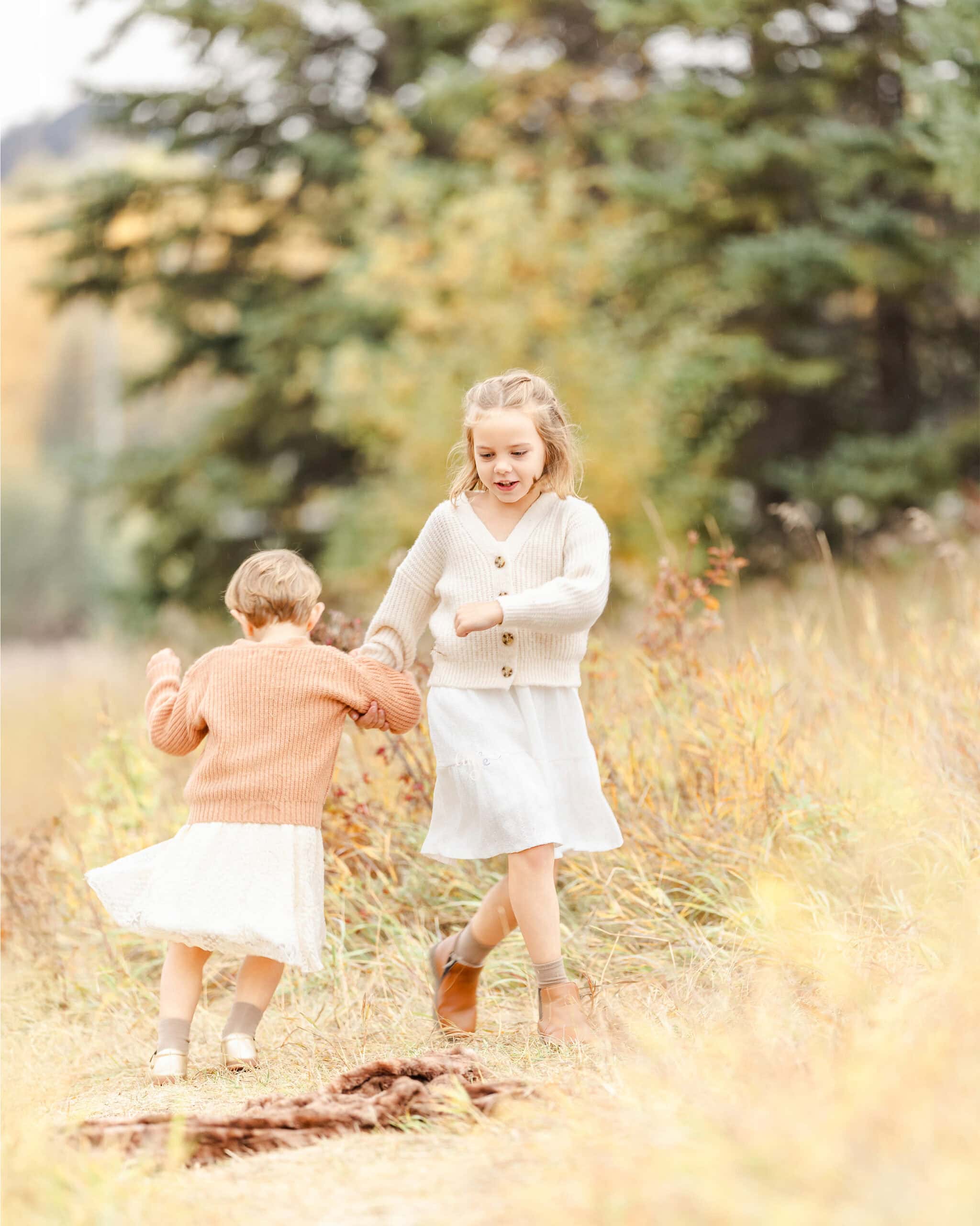 Sibling sister dancing in Edmonton fall enviroment for family photoshoot