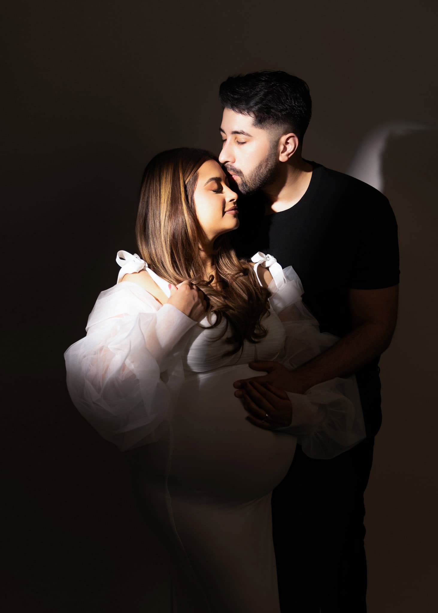 Candid maternity moment with dad-to-be kissing the baby bump – Edmonton photo session