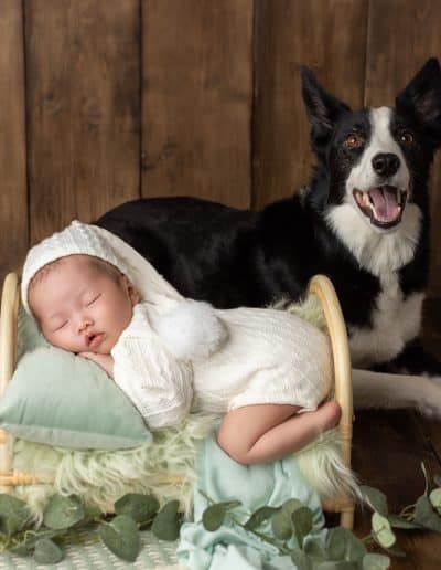 newborn posed on his prop bed with his god in Edmonton Newborn Photography Studio