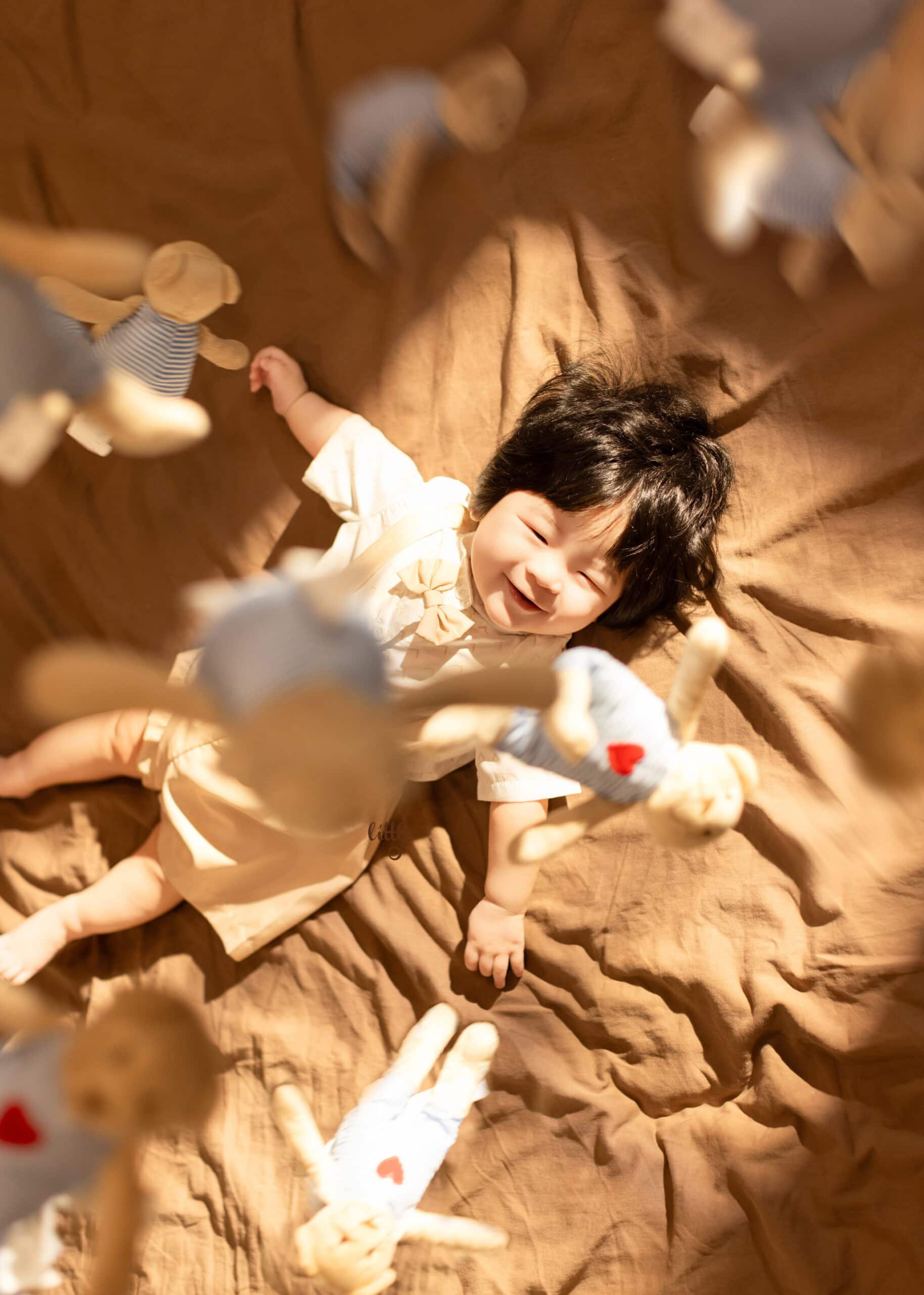 6 months baby boy smiling to his bear toy in an Edmonton baby milestone photoshoot