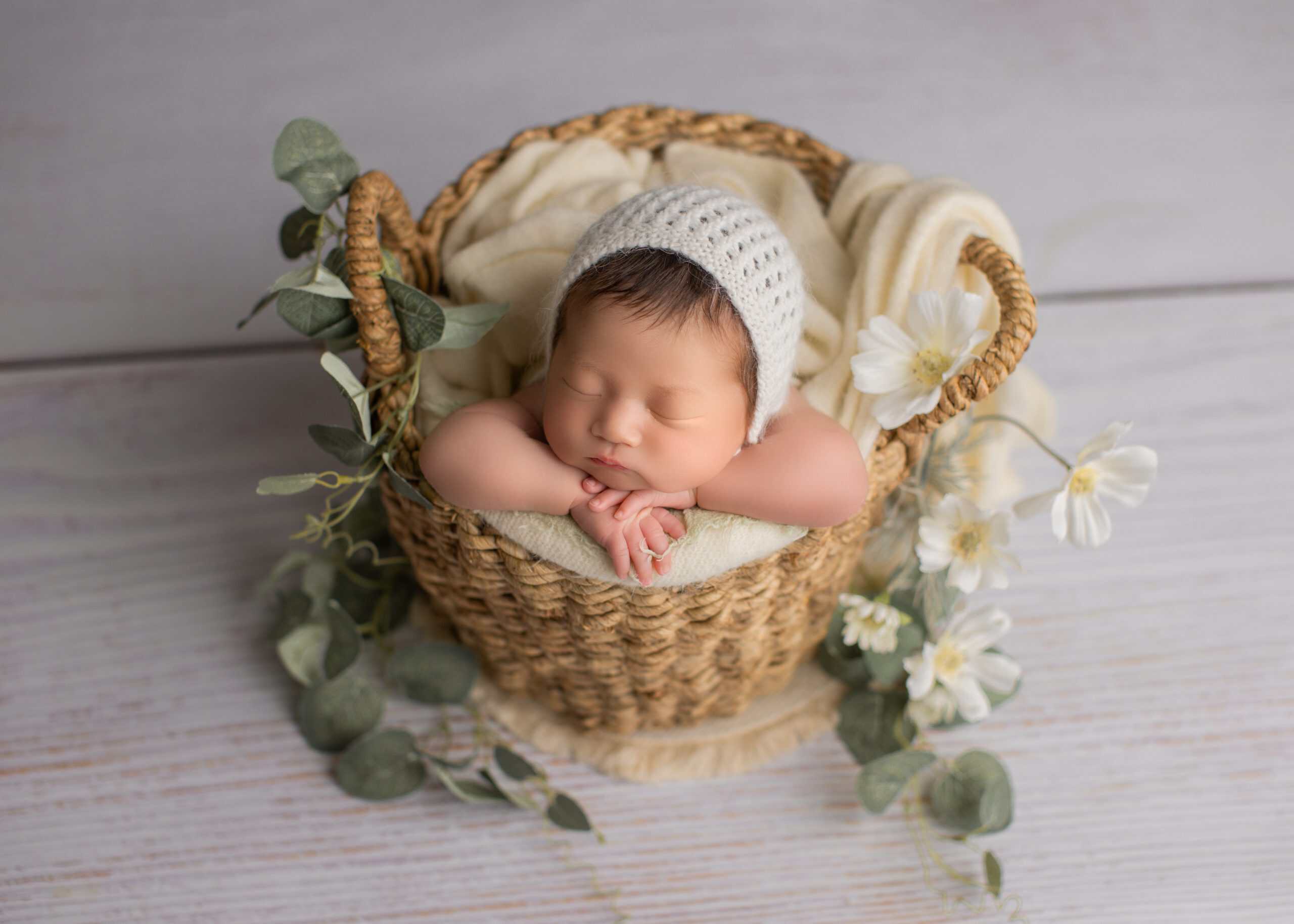 Custmized newborn photo with baby posed on a cream-toned blanket.