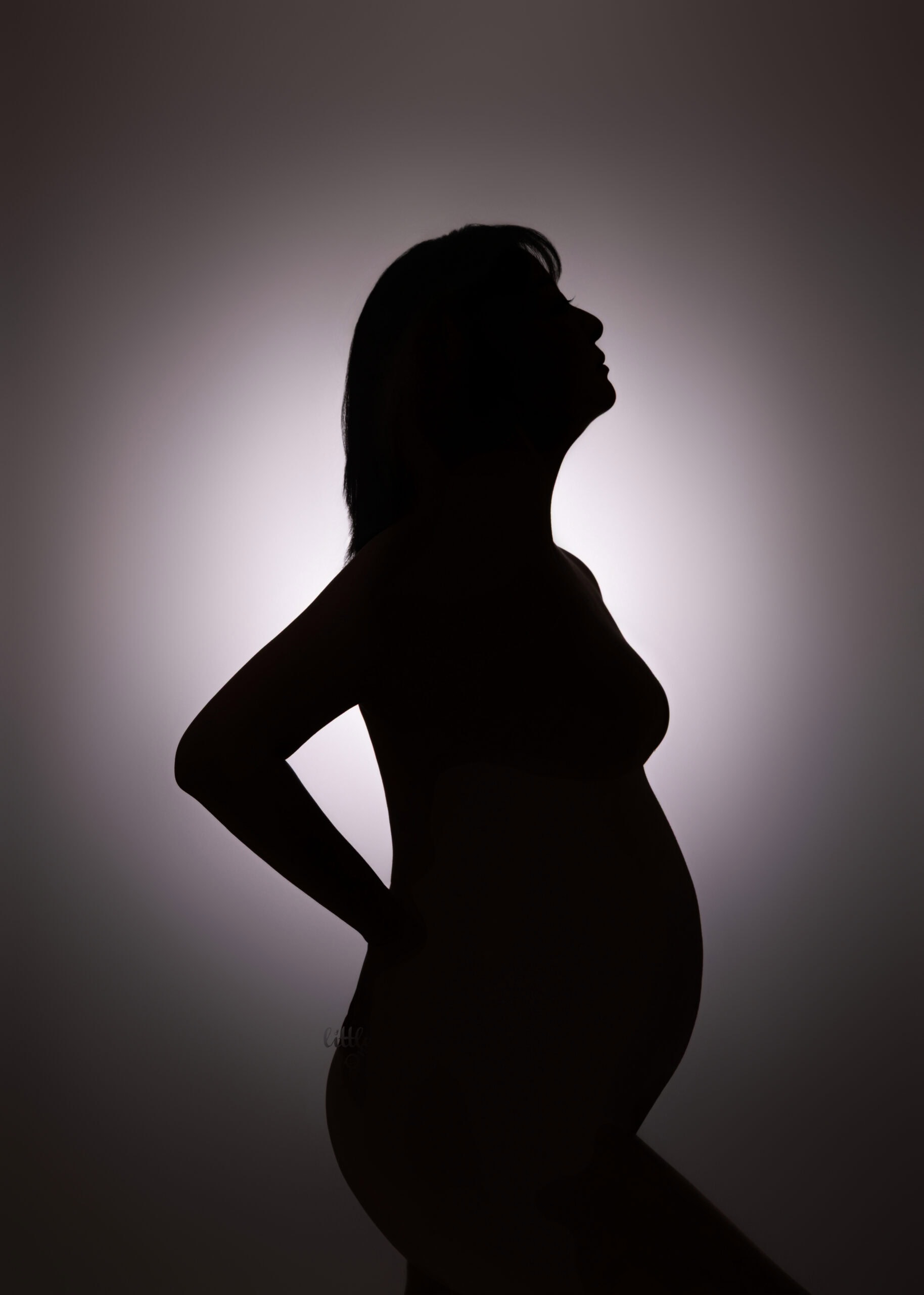 mom-to-be taking her pregnency photo with her body shape showing in a shawdow.
