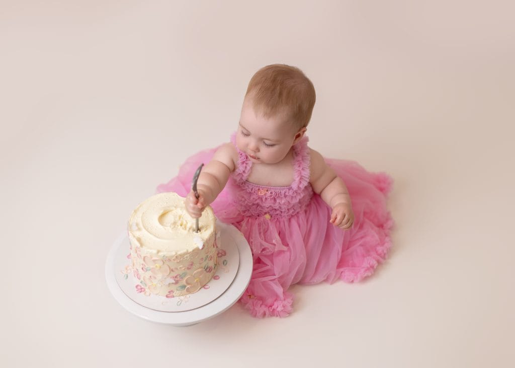 baby is smashing her cake in Edmonton Studio with Little One Photography