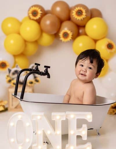 Laughing baby during playful and simple yellow cake smash session.