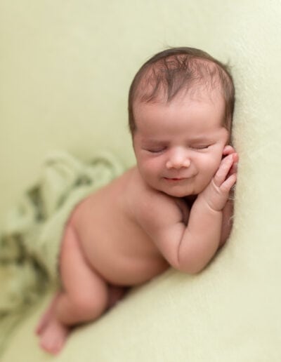 Newborn baby girl sleep in a soft blanket for a newborn photoshoot with timeless feeling