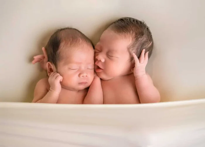 Twin newborns peacefully sleeping side by side during an Edmonton studio session.