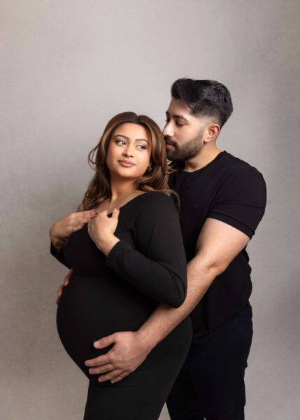 dad holding mom's bump during Edmonton maternity photoshoot